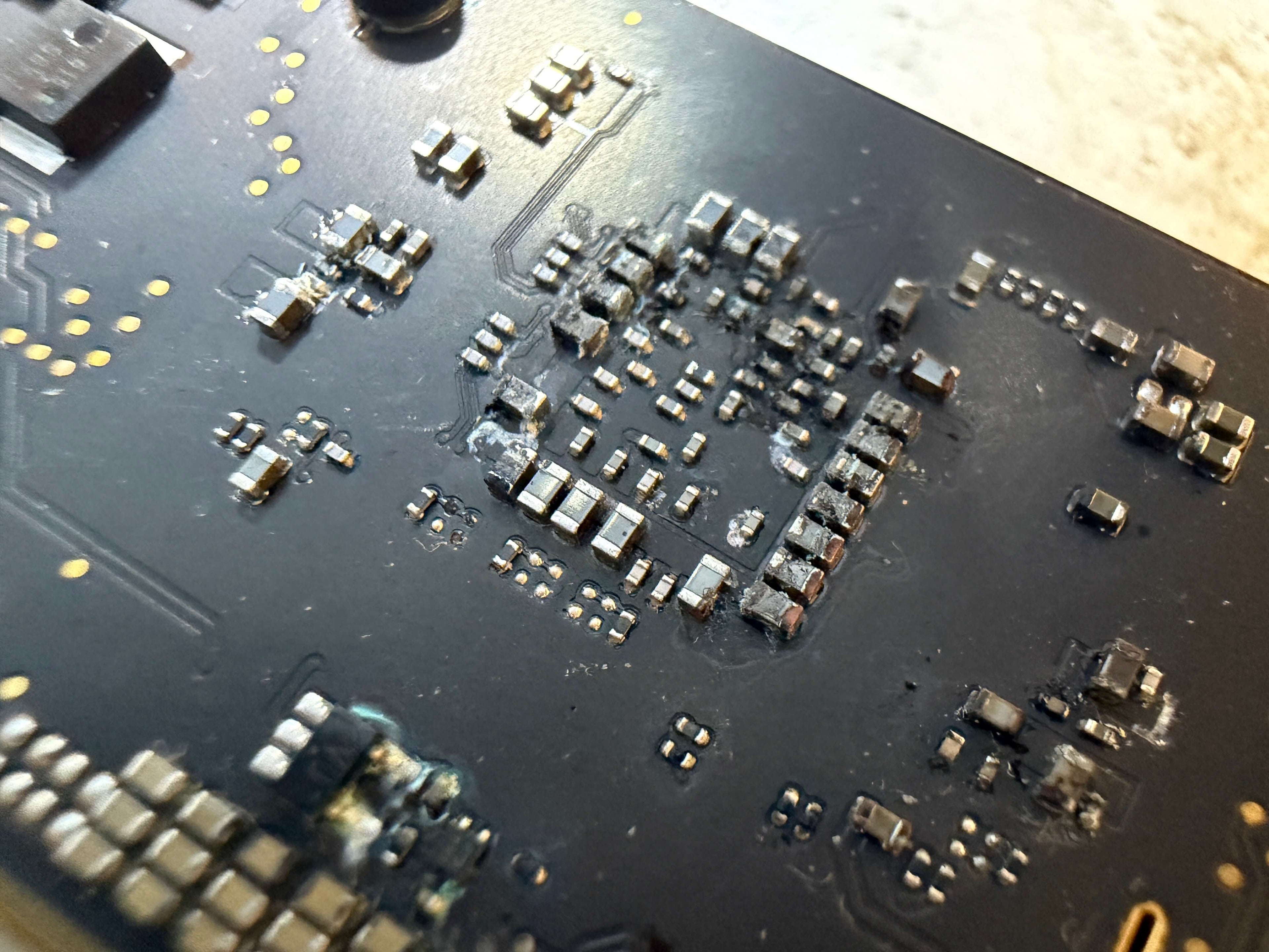 Close up of liquid damaged A3401 logic board, showing corrosion around capacitors and other components